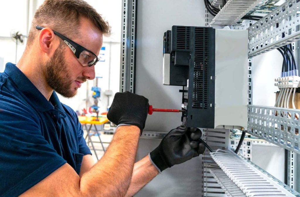 Elektriker utför felsökning i ett elskåp med hjälp av multimeter.